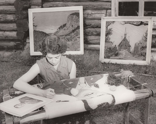 Rug hooking using photo as pattern, examples in background of work