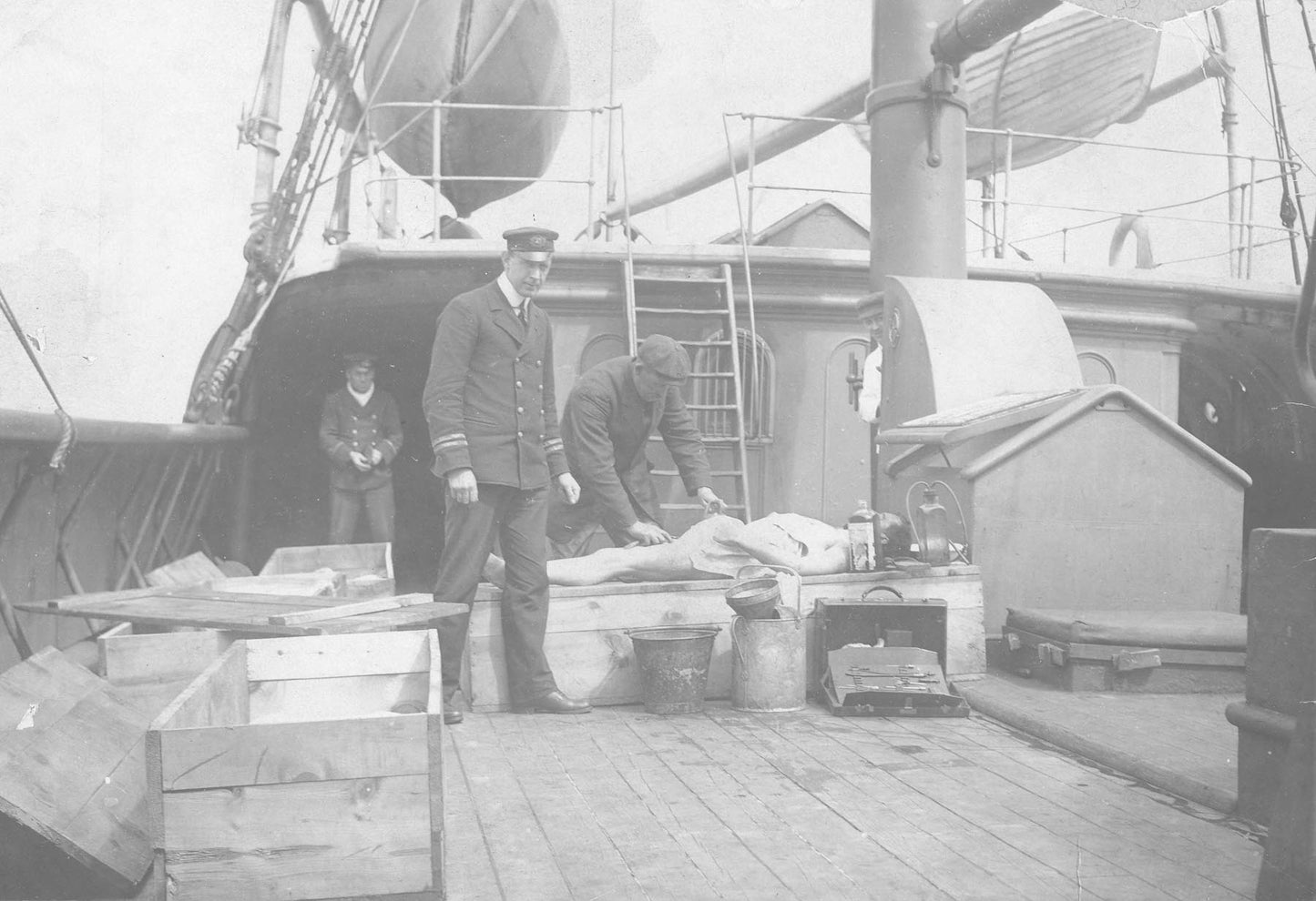 "Body of RMS Titanic victim aboard rescue vessel [CS Minia] being made ready for make-shift coffin"