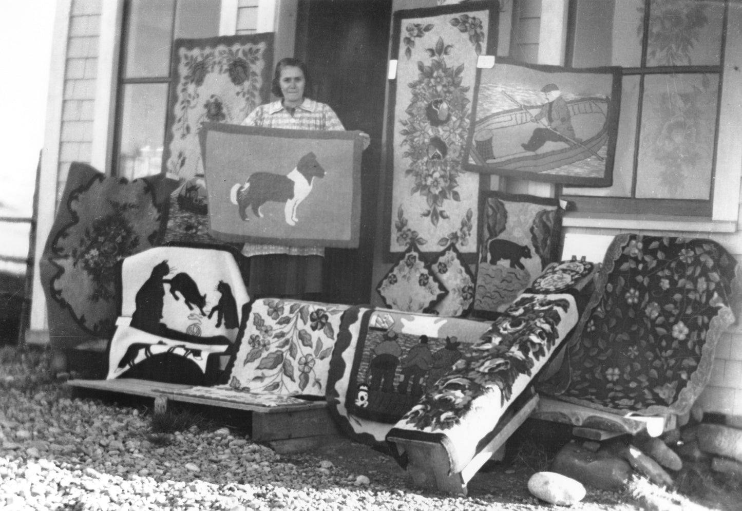 Woman with display of hooked rugs