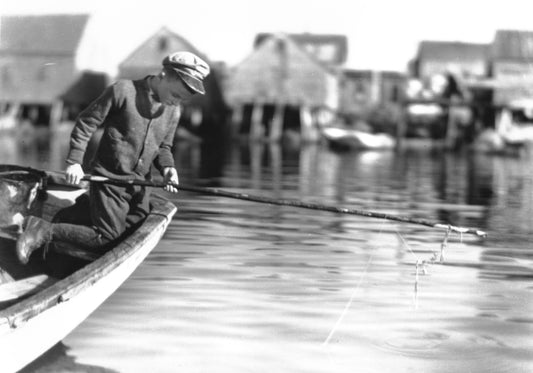 Boy fishing from docked boat, Peggy's Cove, NS