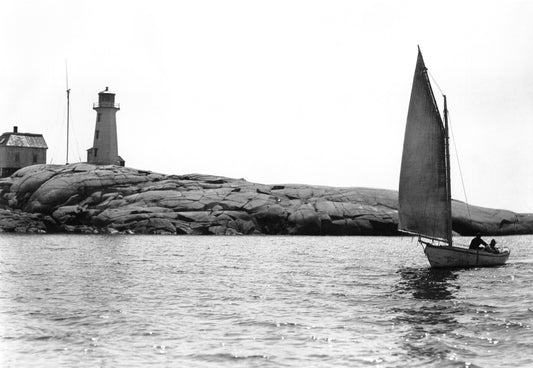 Men in sailboat, lighthouse in background, Peggy's Cove