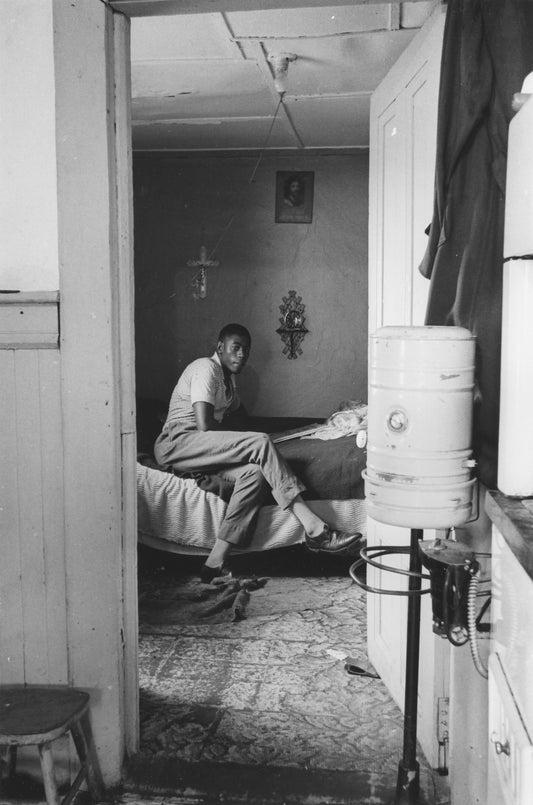 Young man seated in his bedroom, Africville