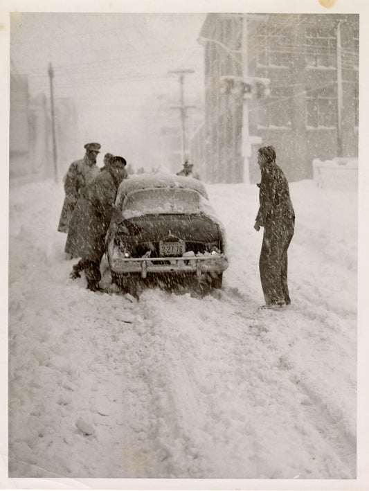 Small car being pushed in blizzard